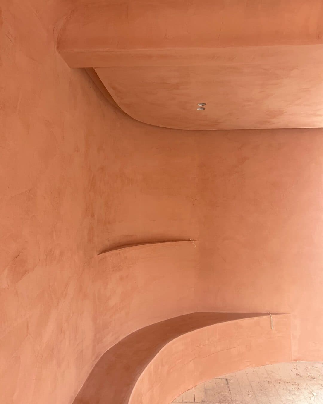 Sculptural curved plaster feature wall in warm tones